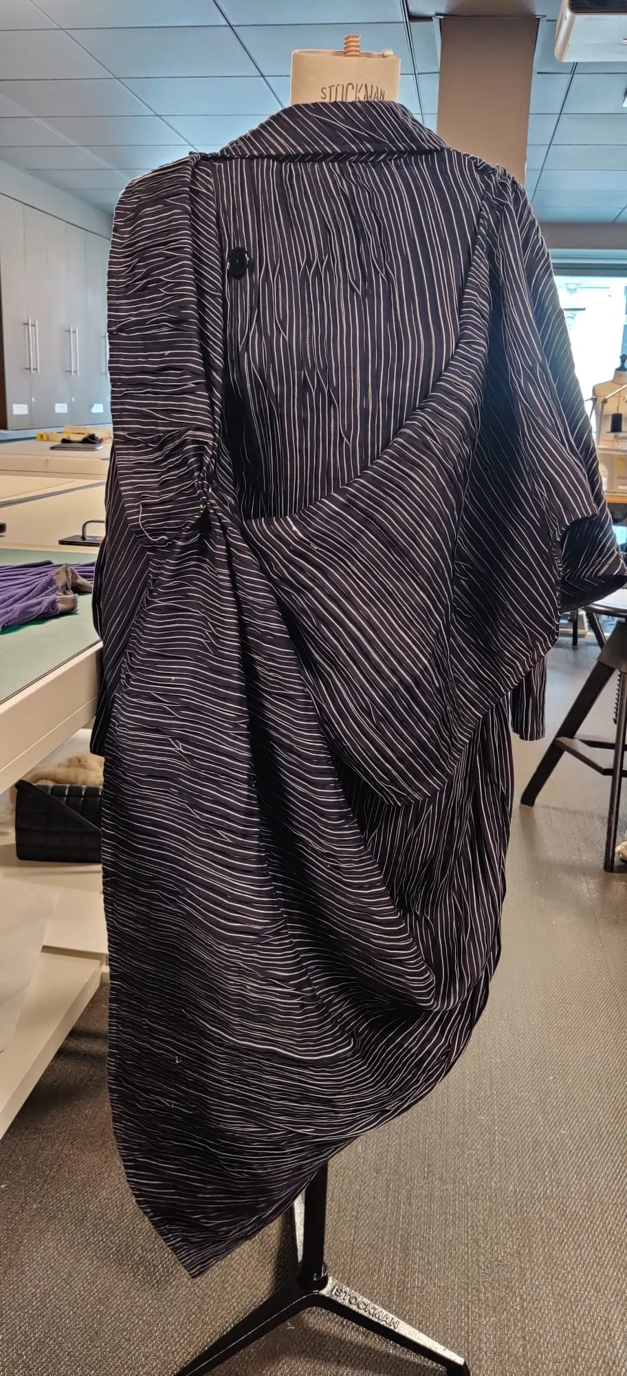 Power Pinstripe Perfection's saree-inspired drape and button closure, shown on a dress form