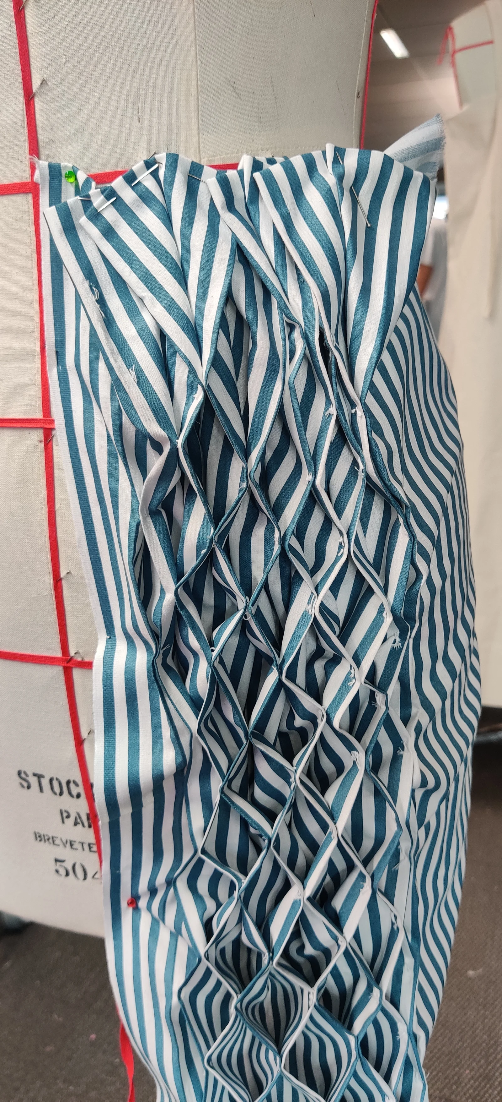 Teal and white pinstripe cotton pinned and smocked on a dress form for The Paralegal Fit's bodice